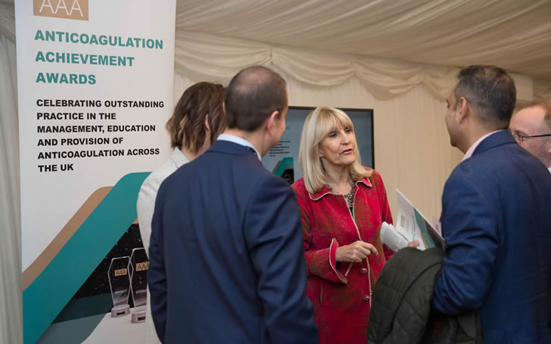 Anticoagulation Achievement Awards - People standing next to roller banner in Houses of Parliament awards event ceremony Image 2